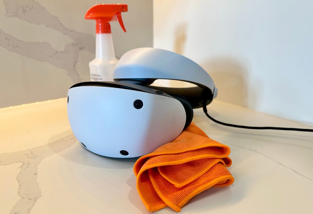 PlayStation VR 2 virtual reality headset with an orange bottle and micro fibre cloth