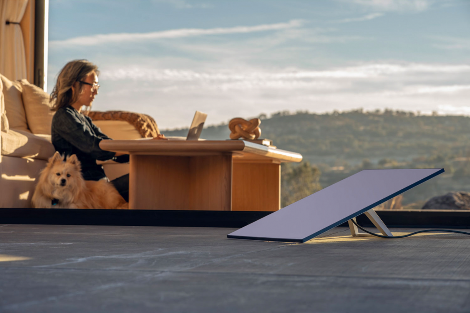 Woman working on her laptop connected to the internet with the Starlink Standard Kit. 