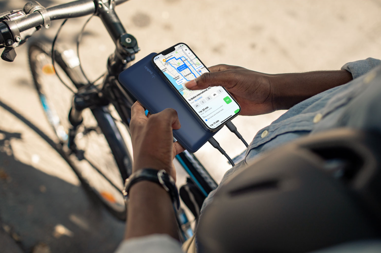 Man using power bank to charge his phone to see directions on the go. 