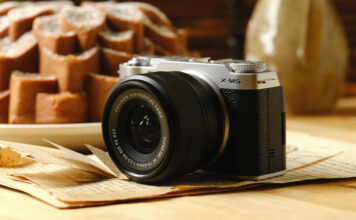 Fujifilm X-M5 resting on a table near food.