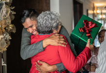 Son greeting mother on christmas at home