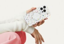 A hand holding an iPhone 16 with the Petite Floral clear Ideal of Sweden phone case against a white background. This person has pink pants and white sleeves but we cannot see their face.