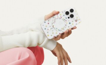 A hand holding an iPhone 16 with the Petite Floral clear Ideal of Sweden phone case against a white background. This person has pink pants and white sleeves but we cannot see their face.