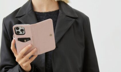 A person holding an iPhone 16 with a pink magnet wallet Ideal of Sweden phone case.