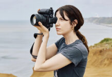 Woman taking photos with Sony Alpha 1 II outdoors.