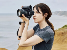 Woman taking photos with Sony Alpha 1 II outdoors.