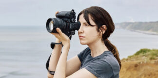 Woman taking photos with Sony Alpha 1 II outdoors.