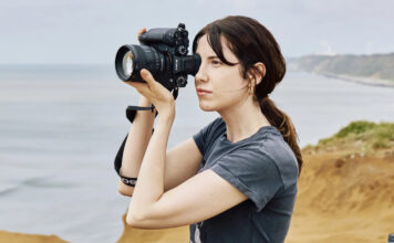 Woman taking photos with Sony Alpha 1 II outdoors.