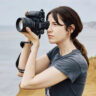 Woman taking photos with Sony Alpha 1 II outdoors.