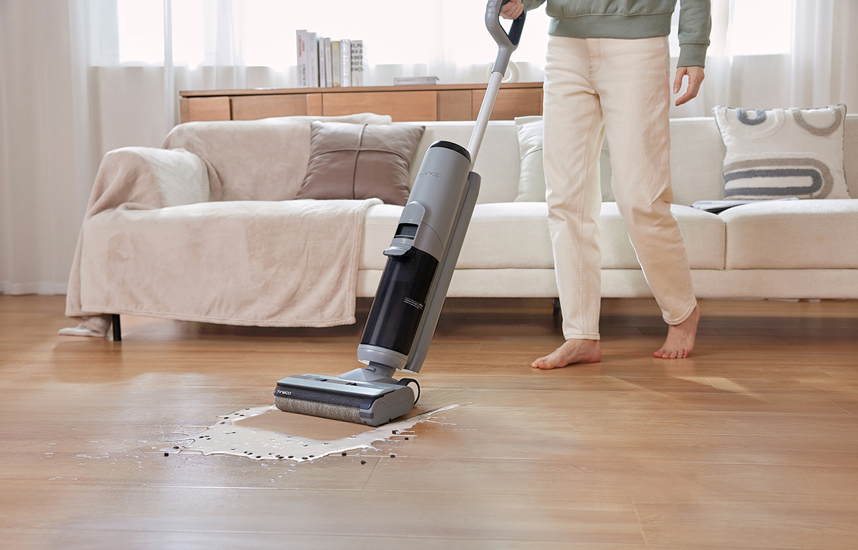 Man cleaning spill in living room with Tineco GO H2O XL.