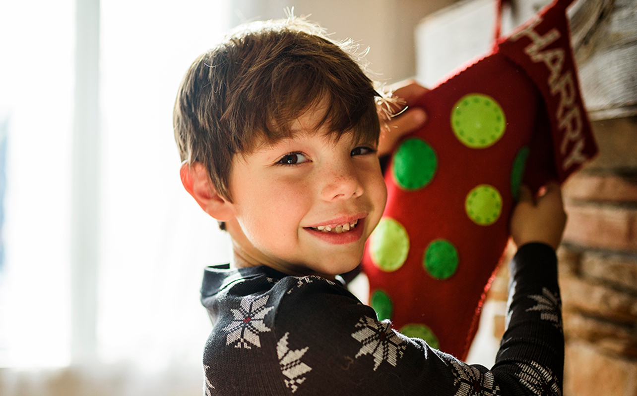 Une jeune garçon qui tient un bas de Noël