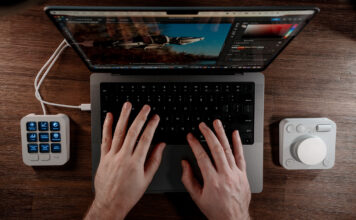 Overhead view of Logitech MX Creative Console flanking a MacBook Pro.