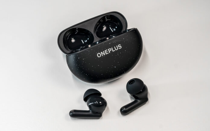 OnePlu sNord Buds 3 Pro earbuds loose in front of open case.