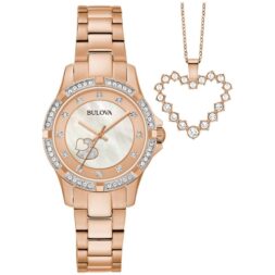 Bulova watch with a rose gold-tone stainless steel case, a bezel with 40 sparkling crystals, and a Mother-of-pearl dial dazzled with 12 crystals and embellished with rose gold-tone double hearts. Comes with a heart pendant in rose gold-tone stainless steel, featuring 18 brilliant crystals.