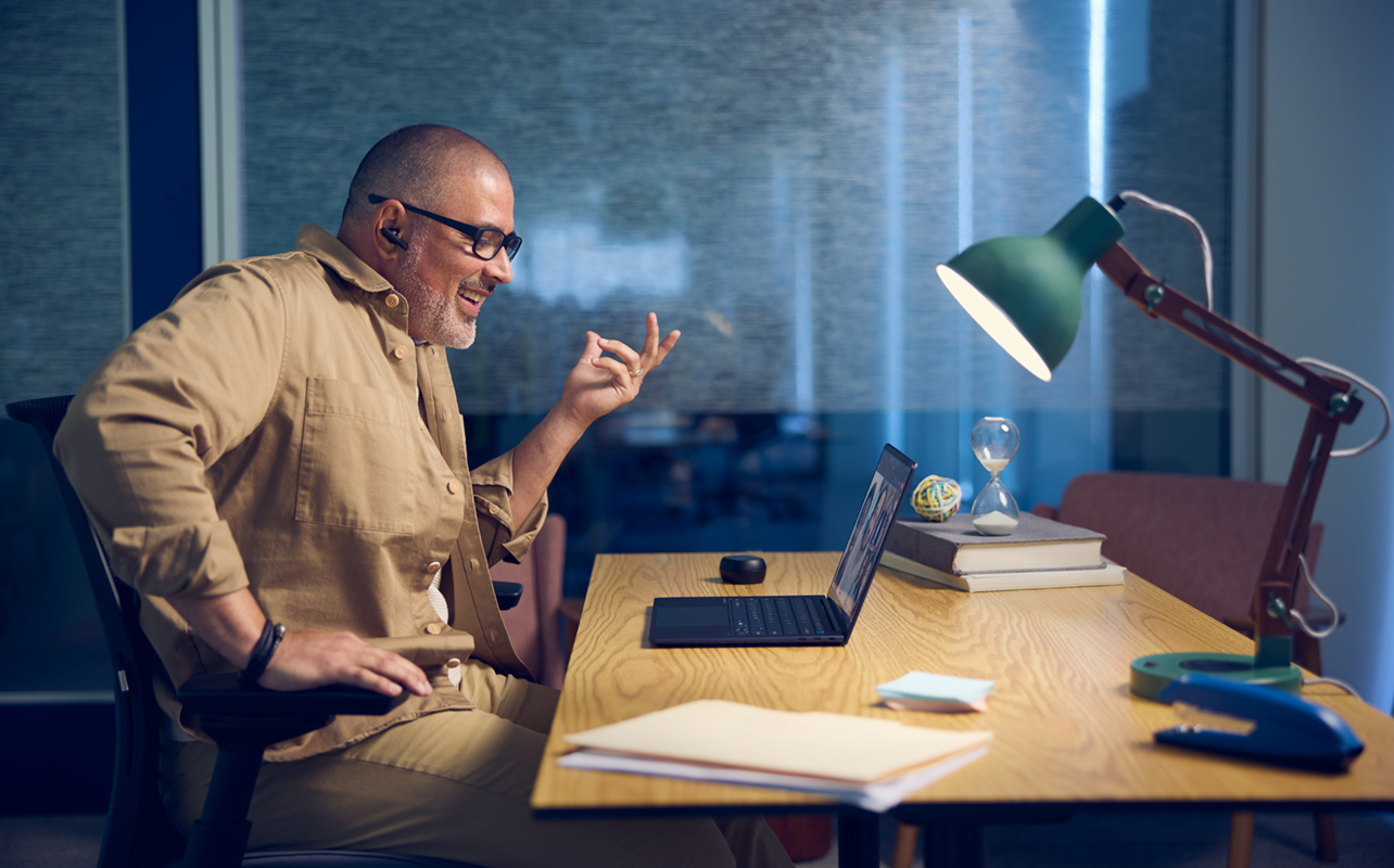 Homme assis devant un ordinateur Elitebook Ultra G1i de HP devant un bureau.