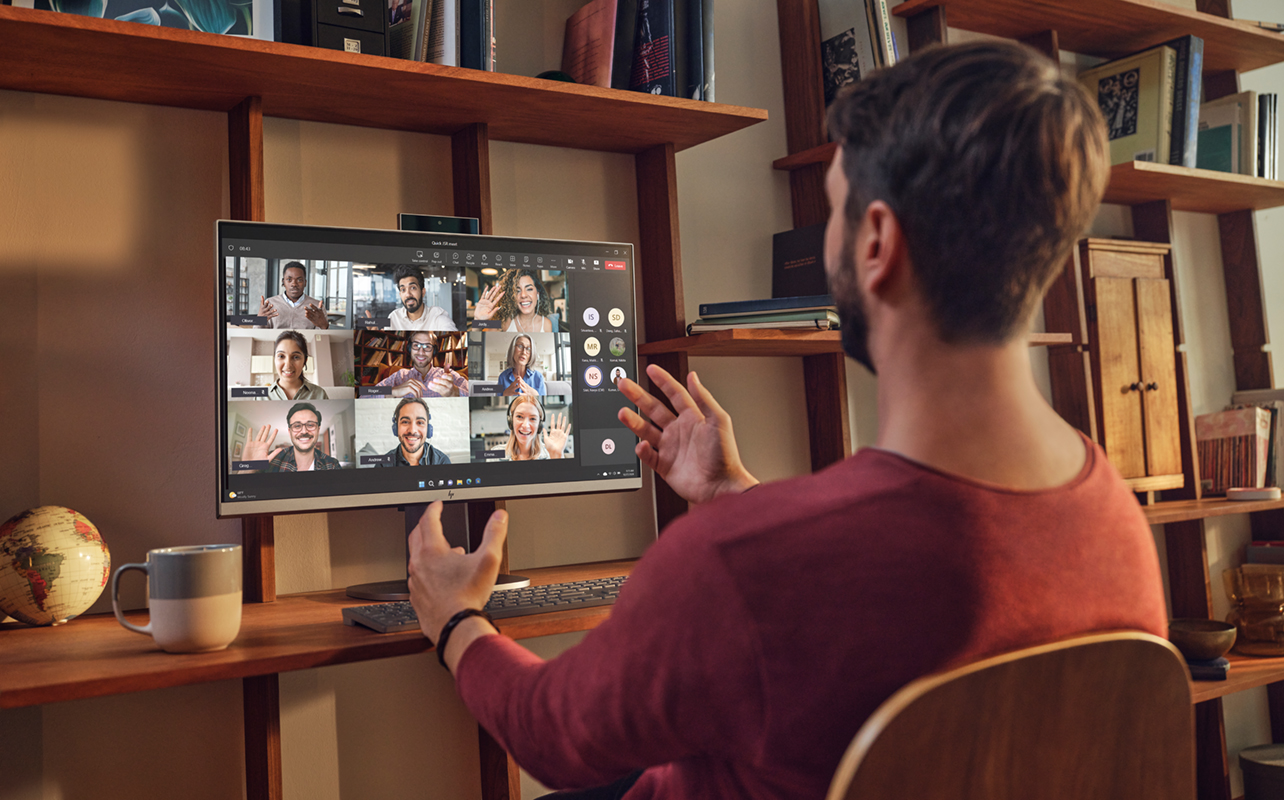 Homme en appel vidéo avec plusieurs collègues sur l'ordinateur de bureau tout-en-un OmniStudio X de HP.