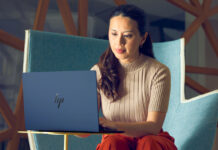 Woman sitting in chair working on HP Elitebook laptop.