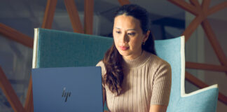 Woman sitting in chair working on HP Elitebook laptop.