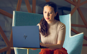 Woman sitting in chair working on HP Elitebook laptop.