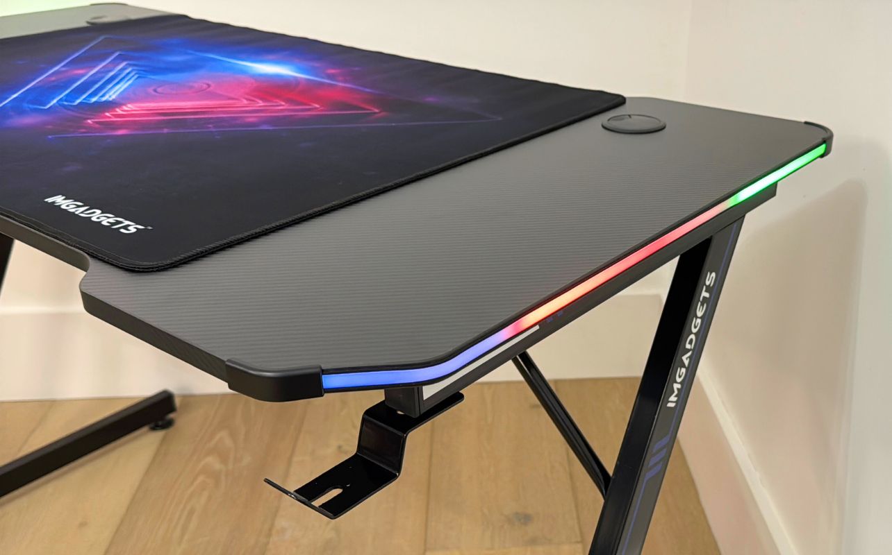 The IMGadgets Z-Shaped Gaming Desk assembled with a close up look at the desk at an angle so you can see the mouse pad on the desk and LED lights on the side.