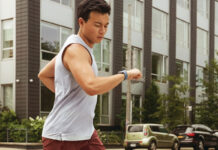 A man running and looking at his smartwatch.