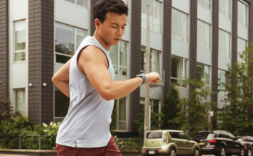 A man running and looking at his smartwatch.