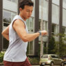 A man running and looking at his smartwatch.