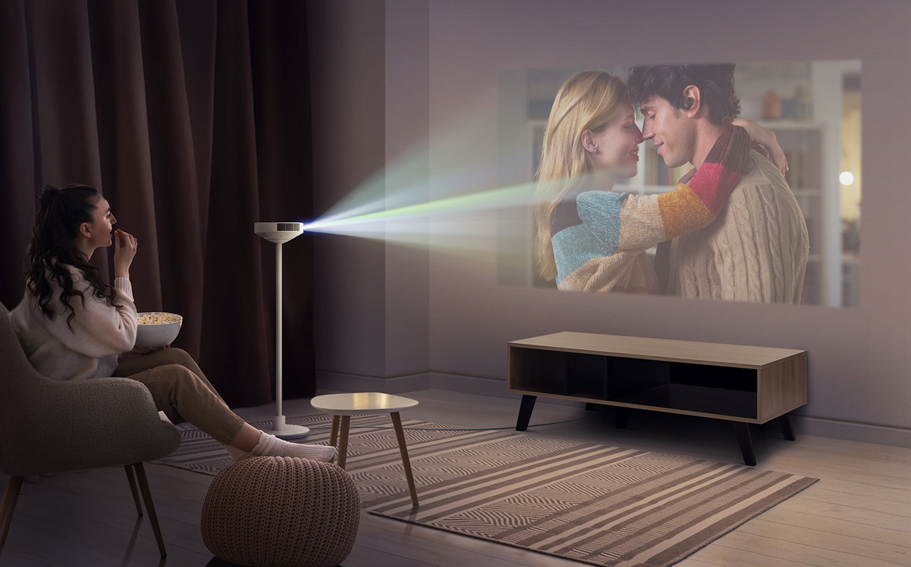 Une femme regarde du contenu sur le projecteur LG 3