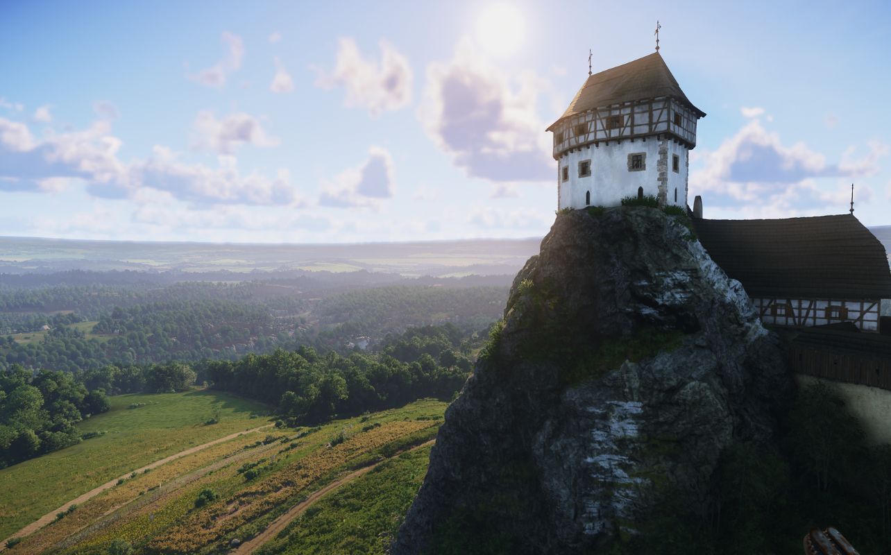 A screenshot of the video game Kingdom Come Deliverance II shows a castle at the top of a mountain with a lush valley stretching off into the distance.