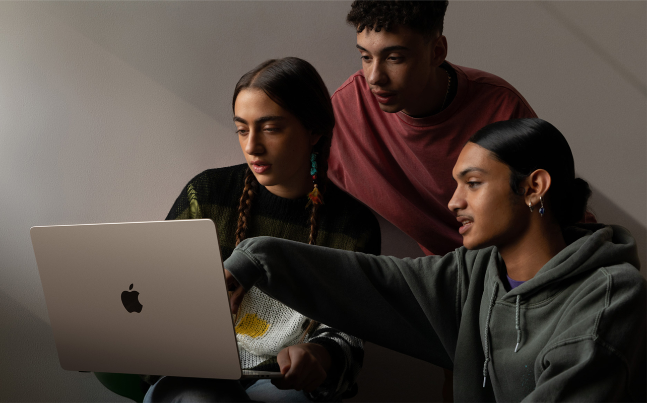 Three people looking at content on a MacBook Air 15-inch.