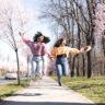 Portrait of the two friends enjoying walk together surrounded by blooming flowers