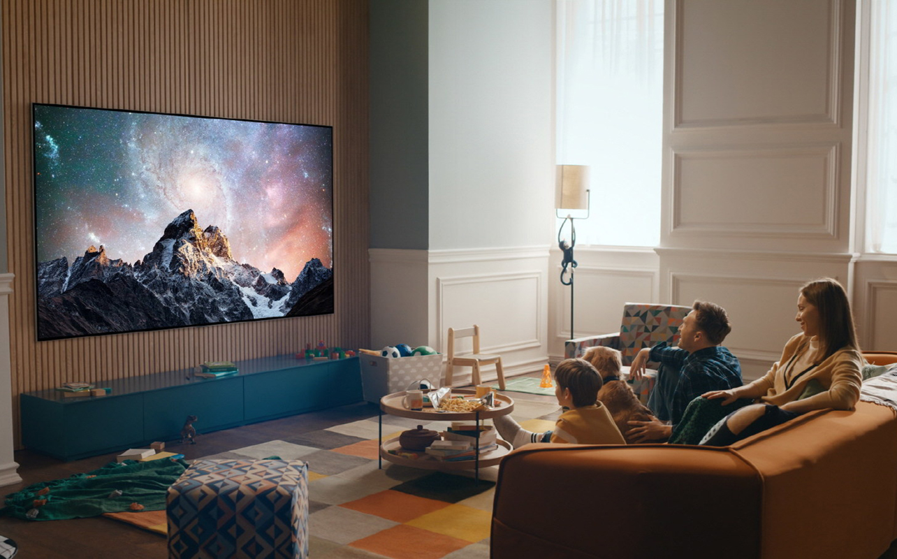 Une famille regarde la télé sur un téléviseur DELO dans son salon