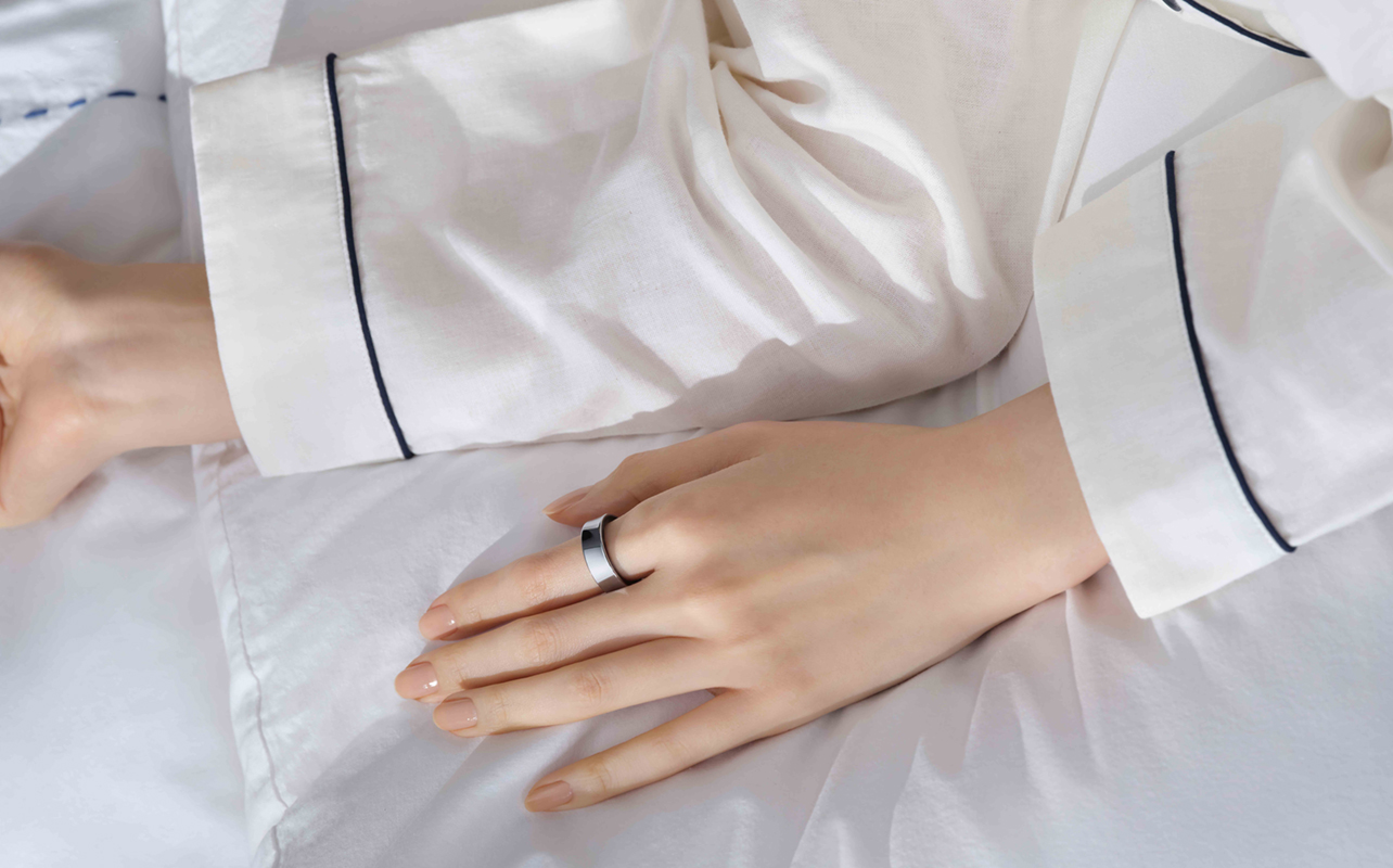 Woman wearing Samsung Galaxy Ring in bed.