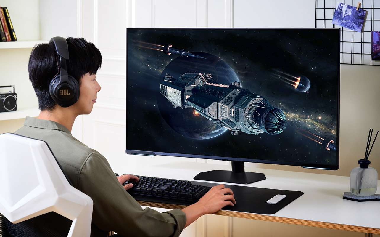 Man playing video games on Samsung Odyssey Neo G7 Mini LED monitor.