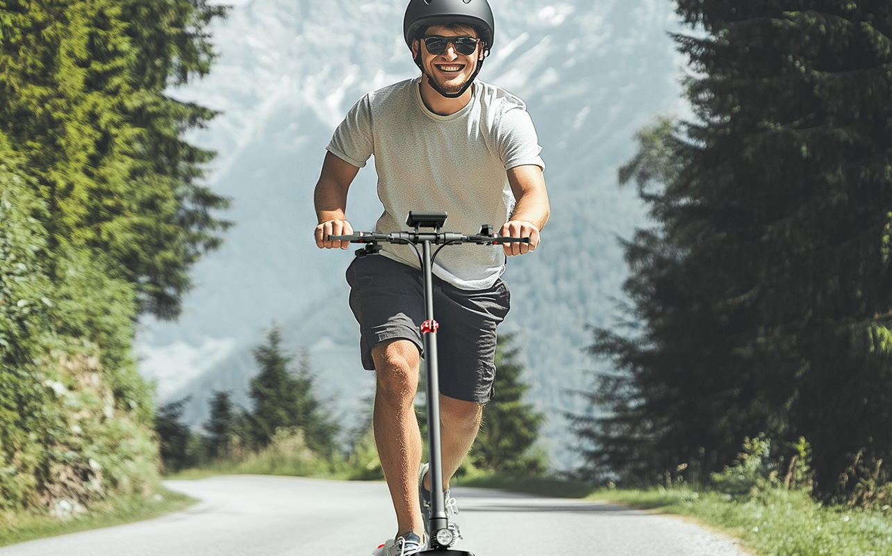 A man riding an iScooter i9 electric scooter and smiling.