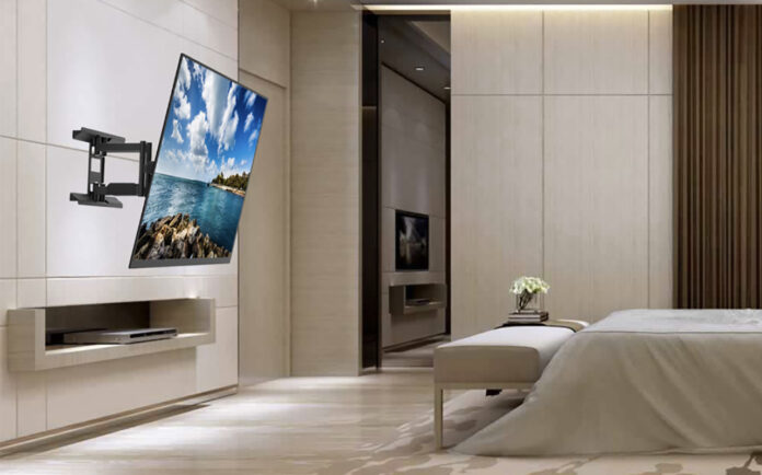 A TV mounted to the wall in a bedroom using a Kanto wall mount.