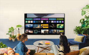 Two women watching an LG TV in a living room with one holding a remote.