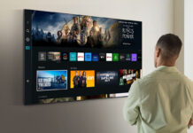 A man standing in front of a Samsung TV smart.