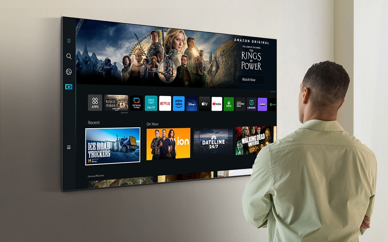 A man standing in front of a Samsung TV smart.