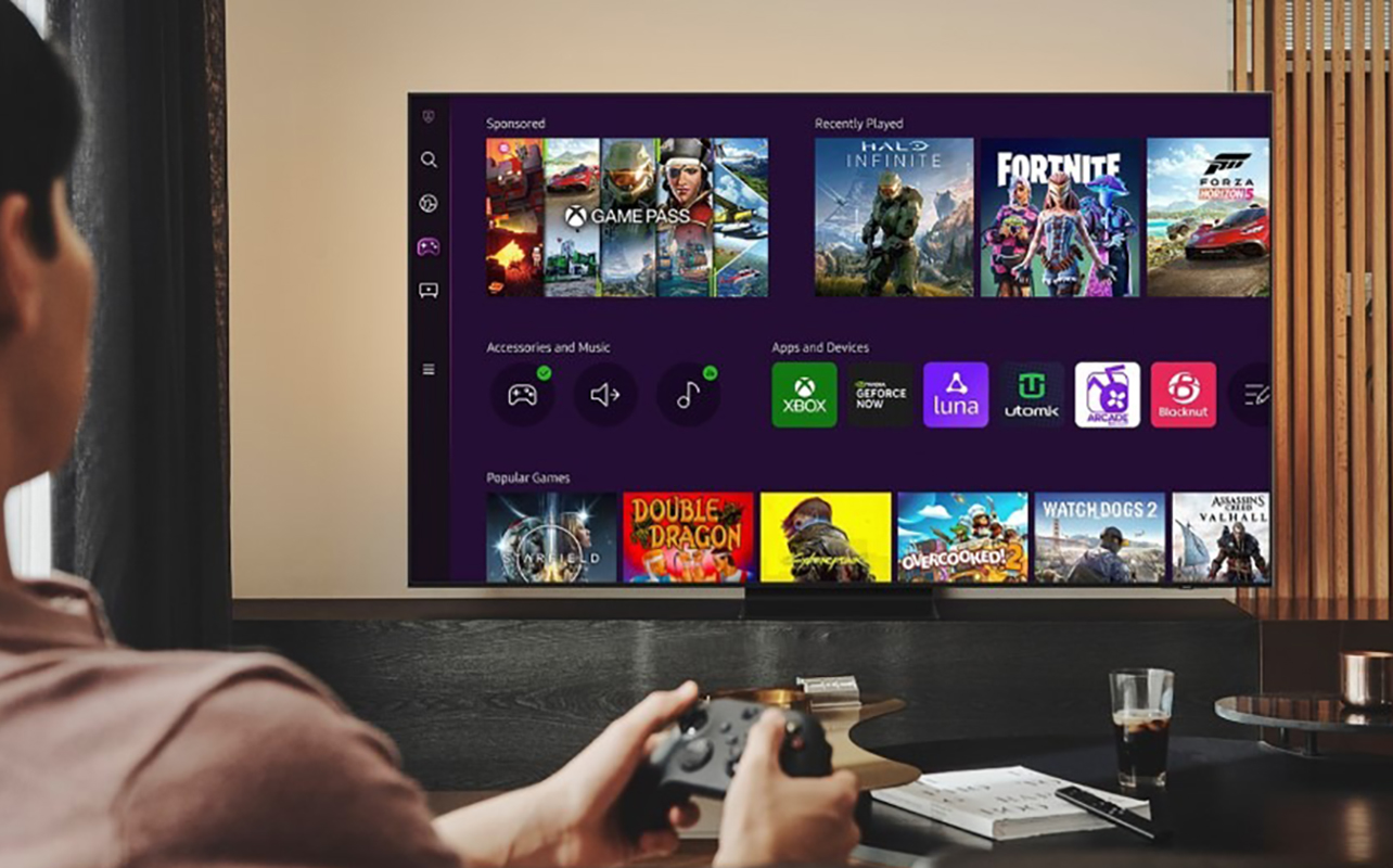 A man gaming with a remote on a Samsung smart TV using Gaming Hub.