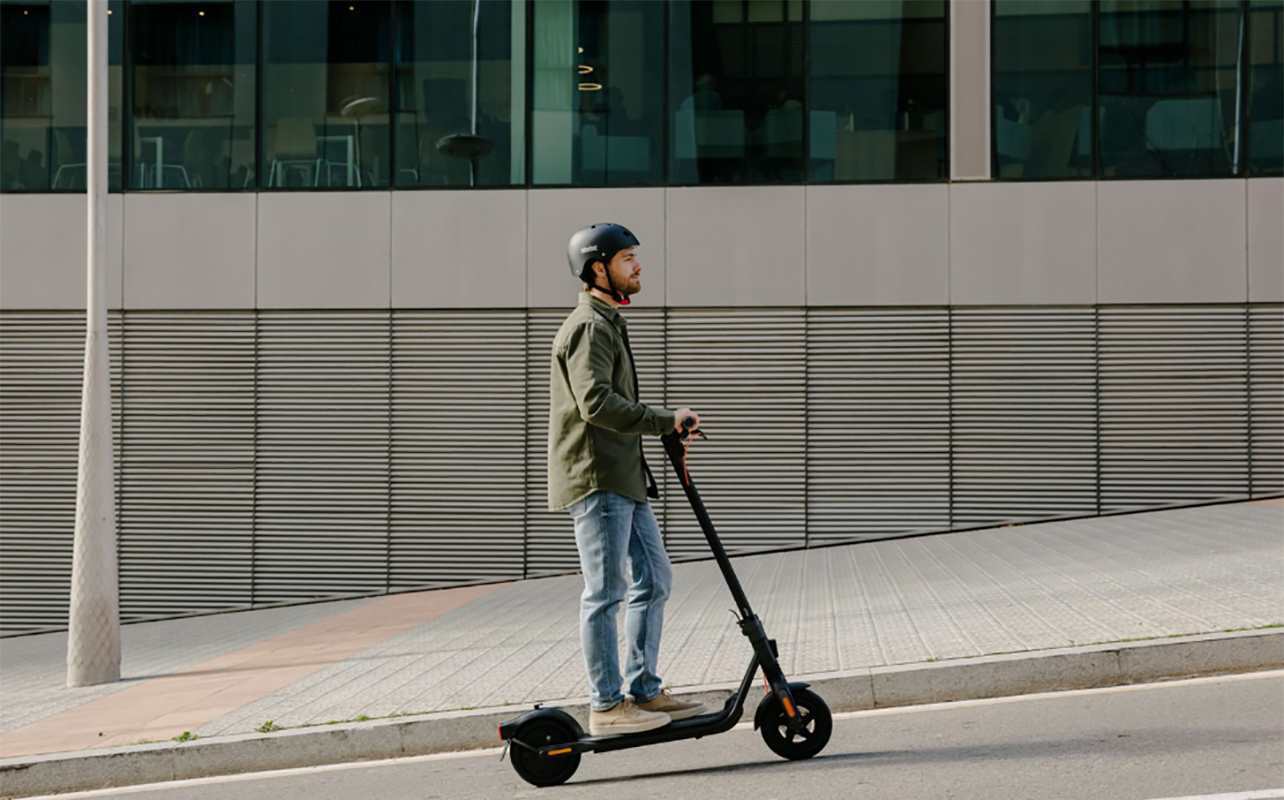 Un homme qui roule sur une trottinette électrique Ninebot de Segway dans la rue. 