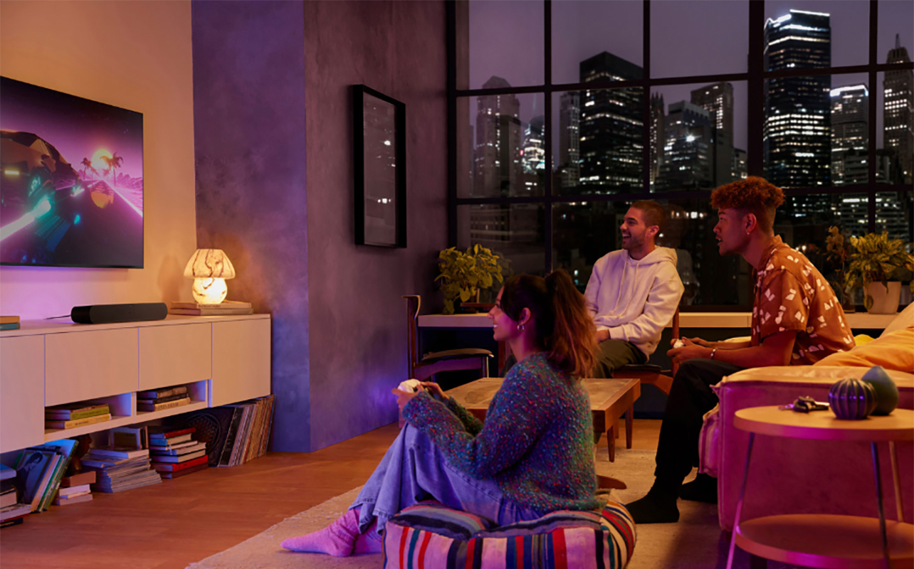 Friends listening to music in the living room with a Sonos Ray sound bar.