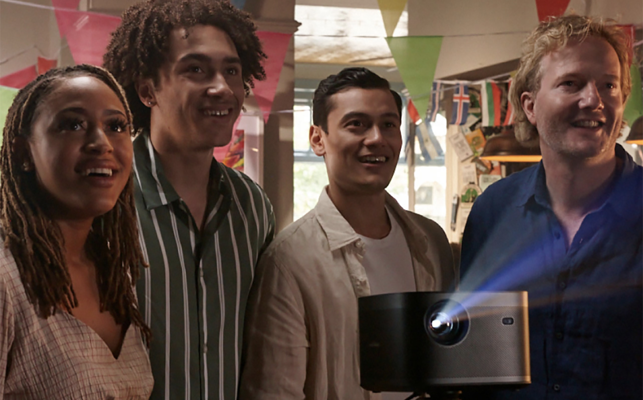 A group of young people looking up at a screen with a projector in front of them
