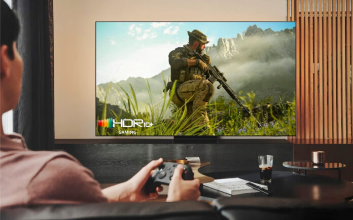 Man playing Call of Duty on HDR10+ TV in living room.