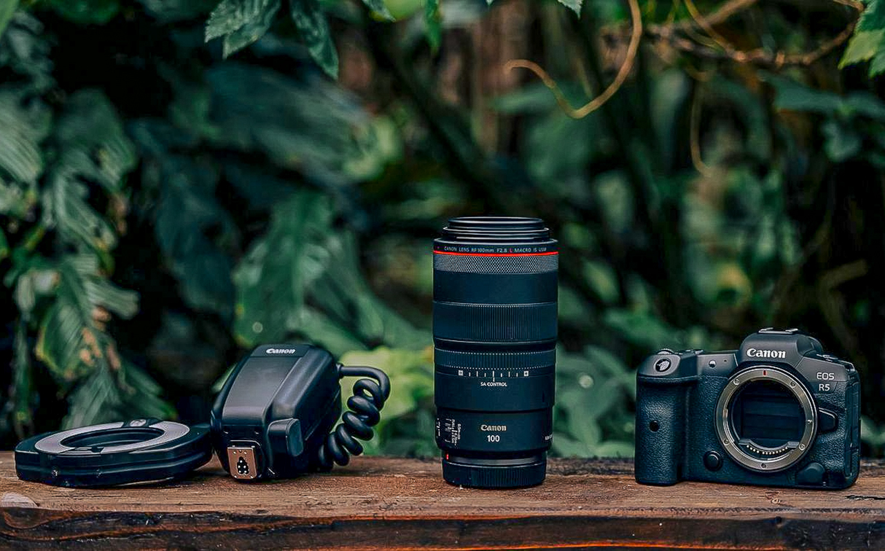 A Canon macro lens kit laid out on wooden table.