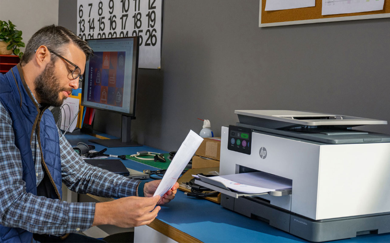 Une personne lit un document imprimé à partir d'une imprimante HP.