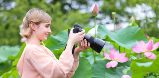 Woman taking photo of flower with macro lens.