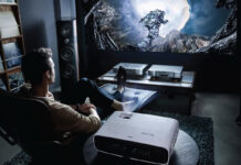 A man sitting back playing games with a BenQ projector.
