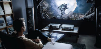 A man sitting back playing games with a BenQ projector.