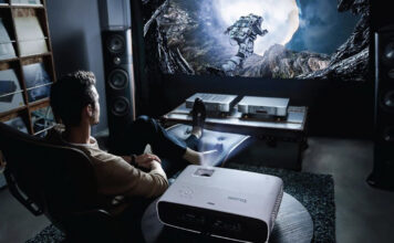 A man sitting back playing games with a BenQ projector.